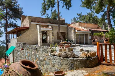 a house with a stone wall in front of it at Platres Forest Panorama Cottage in Platres