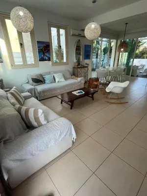 a living room with two couches and a table at Riverland Turtle Beach Villa-1min walk to beach in Protaras
