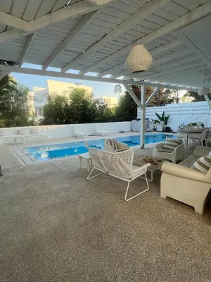 a patio with chairs and a swimming pool at Riverland Turtle Beach Villa-1min walk to beach in Protaras