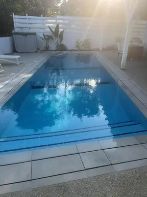 a swimming pool with blue water in a backyard at Riverland Turtle Beach Villa-1min walk to beach in Protaras