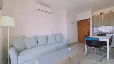 a living room with a couch and a kitchen at STAY Beach Wave Apartment in Larnaka