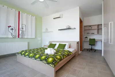 a bedroom with a bed with a green and white blanket at Villa Sea Horizon in Protaras
