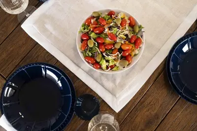 a salad in a bowl on a table with plates at Villa Orchard by Tangerine in Protaras