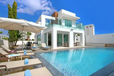 a villa with a swimming pool in front of a house at Villa Indigo in Protaras