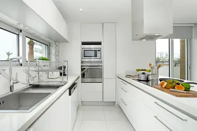 a white kitchen with white counters and appliances at Villa Indigo in Protaras