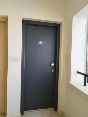 a black door with the number on it at 303 St Lazaros View Studio in Larnaka