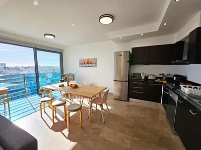 a kitchen with a table and a kitchen with a balcony at Dios Ponte Finikoudes Beachfront in Larnaka