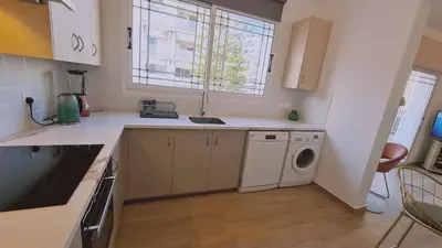 a kitchen with a sink and a washing machine at STAY Sunlit Apartment in Limassol
