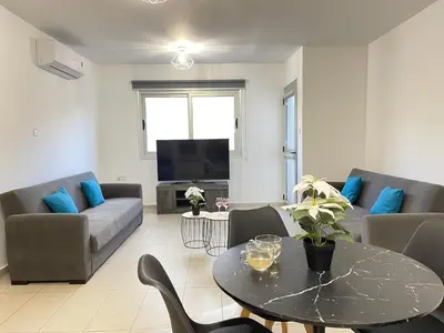 a living room with a couch and a table at Aurora Holiday Apartment - Ayia Napa in Ayia Napa