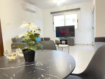 a living room with a table with a plant on it at Aurora Holiday Apartment - Ayia Napa in Ayia Napa