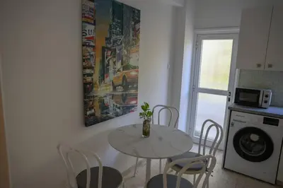 a kitchen with a table and chairs and a microwave at Cozy 2 Bdr Nicosia City Free Parking Wifi in Nicosia