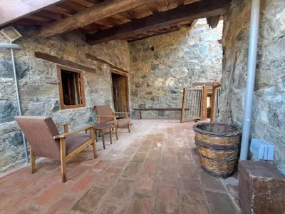 a room with chairs and a table in a stone wall at PITHARIA in Askas