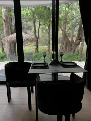 a dining room table with two chairs and a window at River Glamping Kalopanayiotis in Kalopanayiotis