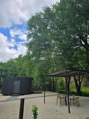 a patio with a table and an umbrella at River Glamping Kalopanayiotis in Kalopanayiotis