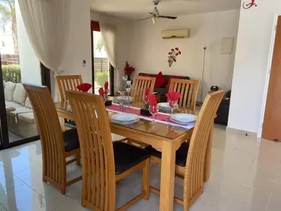 a dining room with a wooden table and chairs at Villa Ocean Breeze in Paralimni