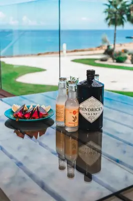 a table with two bottles of alcohol and a plate of food at Protaras Beachfront Thalassa Suite in Protaras