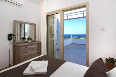 a bedroom with a bed and a view of the ocean at Cape Panorama Villa in Protaras