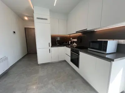 a kitchen with white cabinets and a microwave at Johnny's luxury getaway in Strovolos
