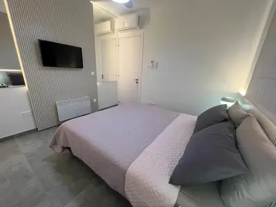a bedroom with a bed and a tv on the wall at Johnny's luxury getaway in Strovolos