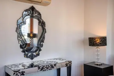 a mirror on a wall next to a table with a lamp at Hallmark Beach by TrulyCyprus in Limassol