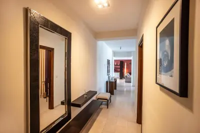 a hallway with a mirror and a chair in a room at Hallmark Beach by TrulyCyprus in Limassol