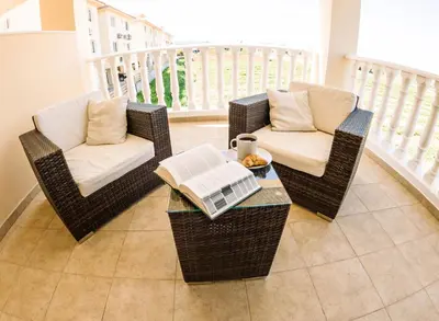 three wicker chairs and a table on a balcony at 3 bed, Kapparis, Thea - 3A in Paralimni