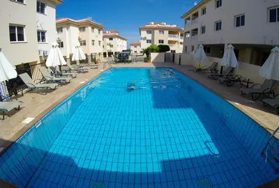 a large blue swimming pool in a courtyard with buildings at 3 bed, Kapparis, Thea - 3A in Paralimni