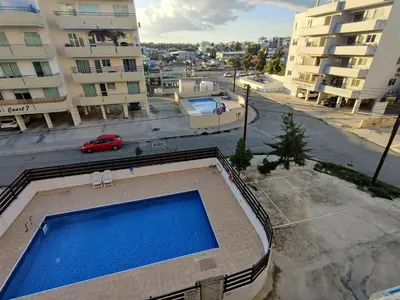 a swimming pool in the middle of a city with buildings at Maestro II Apartment in Larnaka