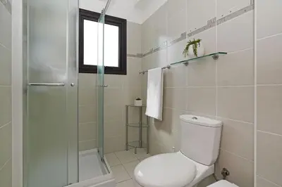 a bathroom with a toilet and a glass shower at Villa Maya - 4bed with Private Heated Pool in Paralimni