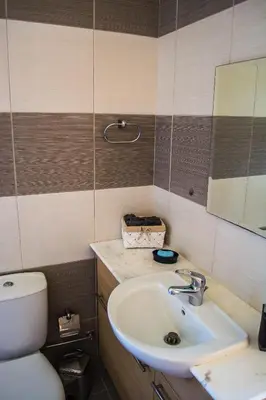 a bathroom with a sink and a toilet and a mirror at Villa Hera in Ayios Theodhoros