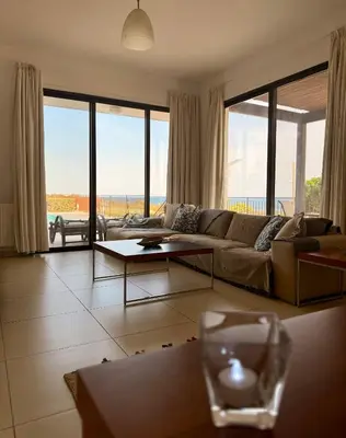 a living room with a couch and large windows at Villa Hera in Ayios Theodhoros