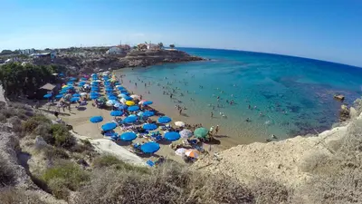 a bunch of umbrellas and people on a beach at 3 bed, Kapparis, Thea - 3C in Paralimni