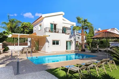a villa with a swimming pool in front of a house at Villa Posidonia - 200m from Sandy Beach in Ayia Napa