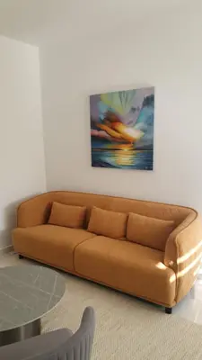 a brown couch in a living room with a painting at Hypnos Residence in Nicosia