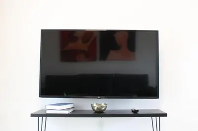 a large flat screen tv on a white wall at Hypnos Residence in Nicosia