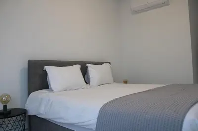 a bedroom with a bed with white sheets and pillows at Hypnos Residence in Nicosia