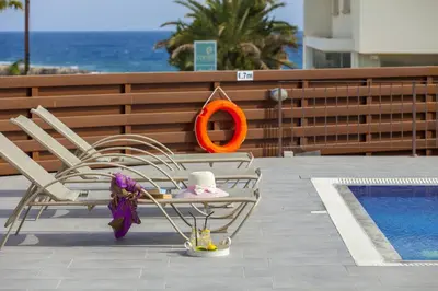two dolls sitting on a table next to a pool at Theodora in Protaras