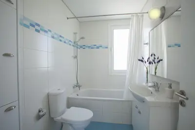 a white bathroom with a toilet and a sink at Protaras Seafront Villa Melissa in Protaras