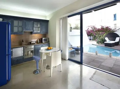 a kitchen with a table and a kitchen with a pool at Protaras Nausicaa Villa Mykonos in Protaras