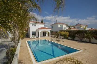 a swimming pool in front of a house at Ayia Thekla Sea Front in Ayia Napa