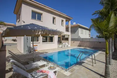 a house with a swimming pool in front of a house at Protaras Seaside Villa Michelle 10 in Protaras