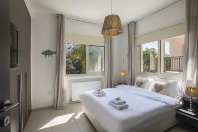 a bedroom with a large white bed with towels on it at Protaras Seaside Villa Michelle 10 in Protaras
