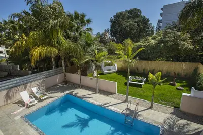 a swimming pool in a yard with palm trees at Protaras Seaside Villa Michelle 10 in Protaras