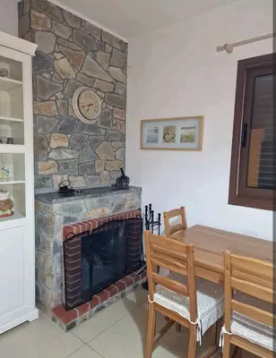 a living room with a stone fireplace and a wooden table at Butterfly Home in Platres