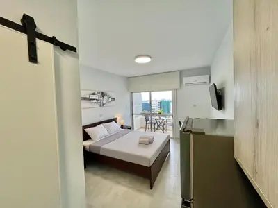 a small bedroom with a bed and a balcony at Enaerios SeaView Studio in Limassol