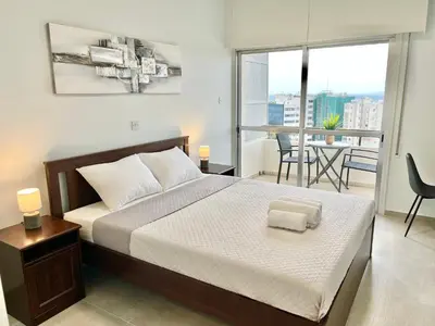 a bedroom with a bed and a balcony at Enaerios SeaView Studio in Limassol