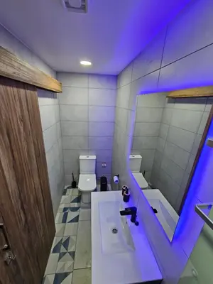 a bathroom with a toilet and a sink and a mirror at THE CLIFF ALONA in Alona