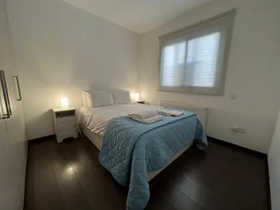 a small bedroom with a bed and a window at Majestic Boutique Apartment/2BR in Nicosia