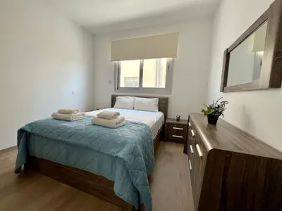 a bedroom with a bed with two towels on it at Kings Boutique Apartment/2BR in Strovolos