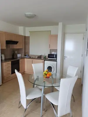 a kitchen with a glass table and white chairs at Holiday Apartment with Sea View (0002913) in Paralimni